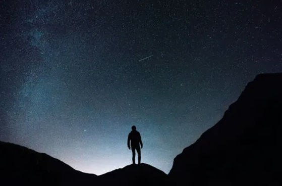 Silhouette of a person under a starry night sky