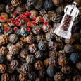 Black peppercorns with a small perfume bottle